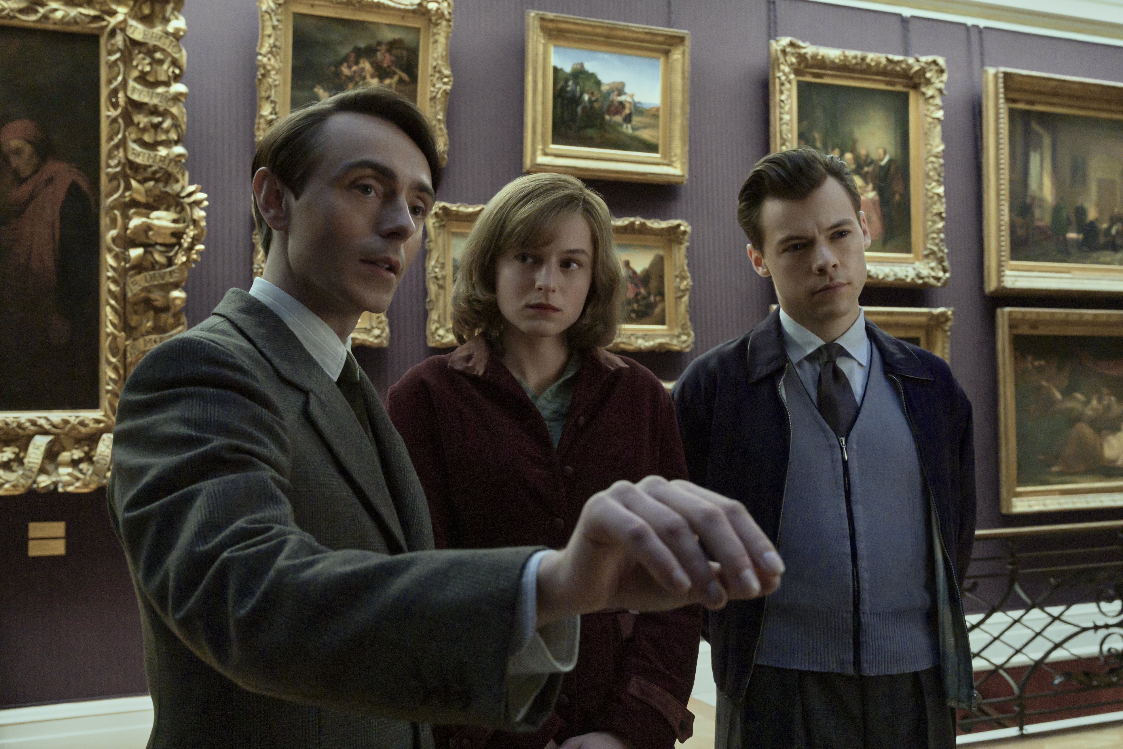 Three young people looking at art.